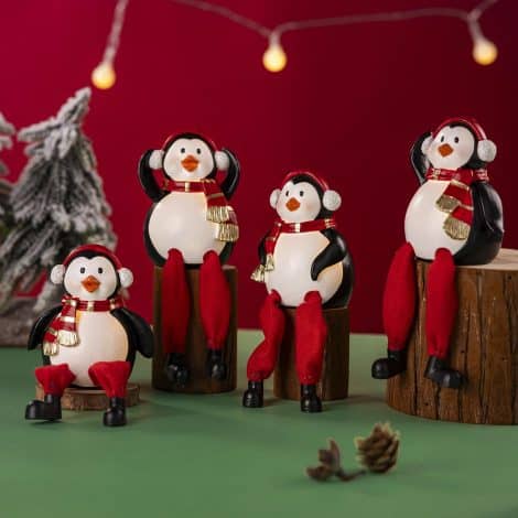 Light up Penguin Christmas Decor, set of 4 resin figurines with dangling legs for indoor holiday decor.